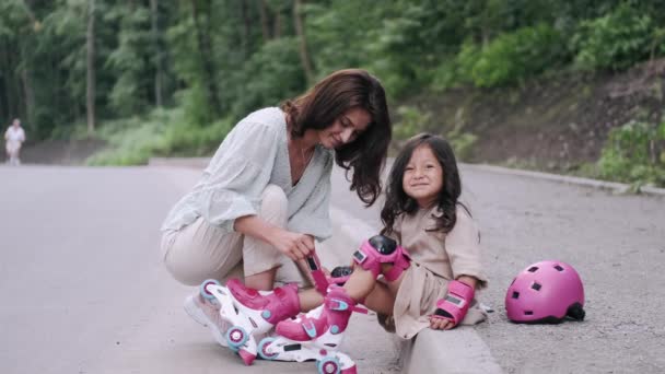 Ibu cantik dan anak di rollerblades di jalan — Stok Video