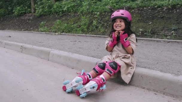 Malá dívka v helmě je uvedení ochranné prostředky na silnici — Stock video
