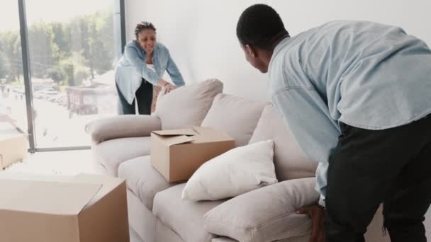 Afrykanin mężczyzna i kobieta wymieniają kanapę w nowym nowoczesnym mieszkaniu — Wideo stockowe