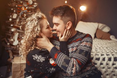 Noel ağacının yanında oturan zarif bir çift.