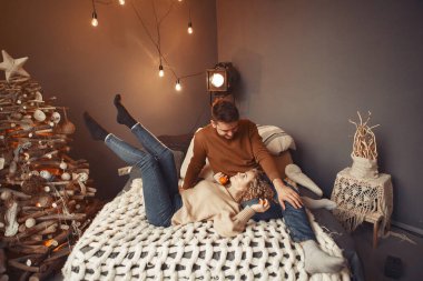 Noel ağacının yanında oturan zarif bir çift.