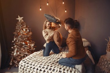 Noel ağacının yanında oturan zarif bir çift.