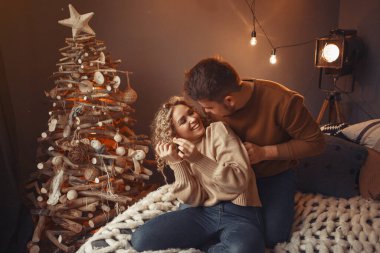 Noel ağacının yanında oturan zarif bir çift.