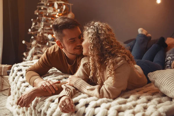 Elegant par sitter hemma nära julgran — Stockfoto