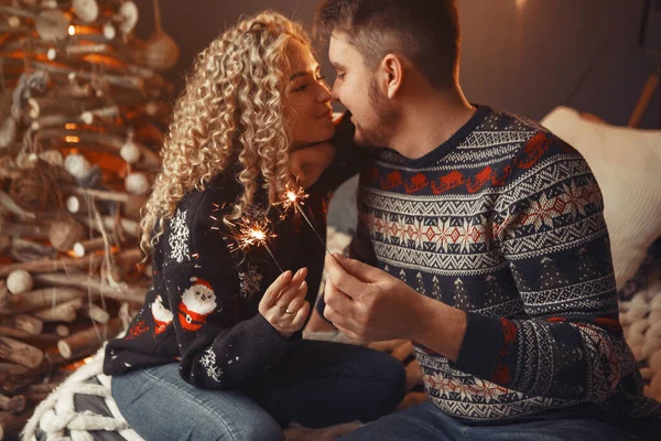 Casal elegante sentado em casa perto da árvore de Natal — Fotografia de Stock