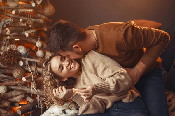 Κομψό ζευγάρι κάθεται στο σπίτι κοντά στο χριστουγεννιάτικο δέντρο — Φωτογραφία Αρχείου