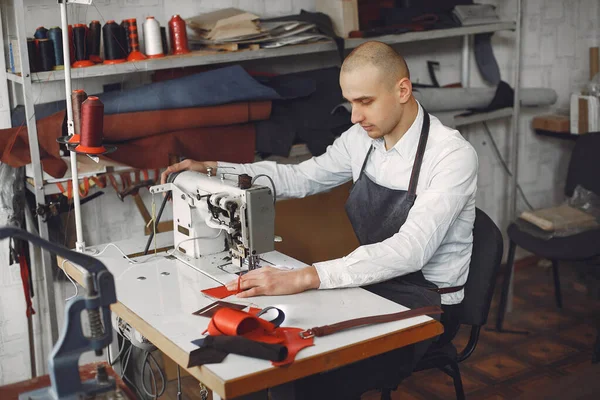 Egy férfi a stúdióban bőrcuccokat készít. — Stock Fotó