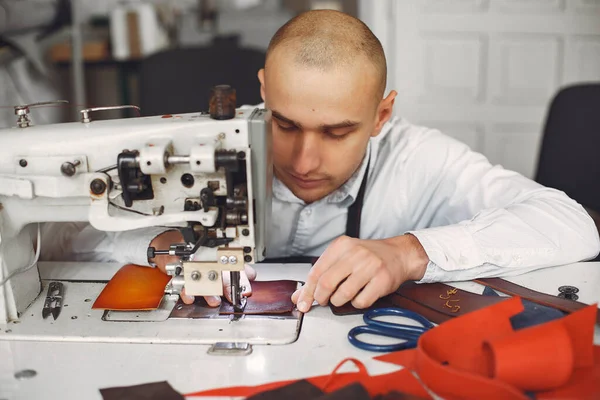 Egy férfi a stúdióban bőrcuccokat készít. — Stock Fotó