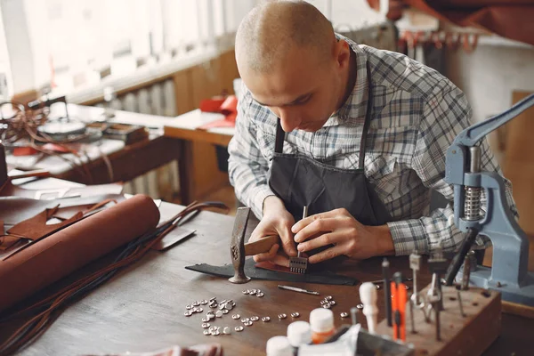 Egy férfi a stúdióban bőrcuccokat készít. — Stock Fotó