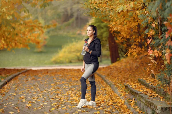 Jaki sport lubisz najbardziej? girl in a black top training in a autumn park — Zdjęcie stockowe