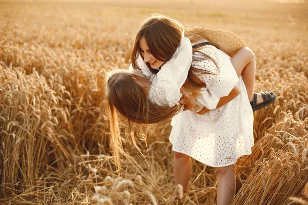 Mor med dotter på ett vetefält — Stockfoto