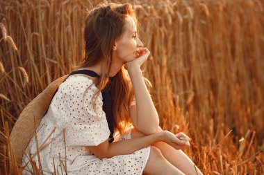 Sonbahar buğday tarlasında zarif bir kız.