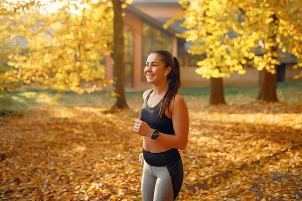 Jaki sport lubisz najbardziej? girl in a black top training in a autumn park — Zdjęcie stockowe