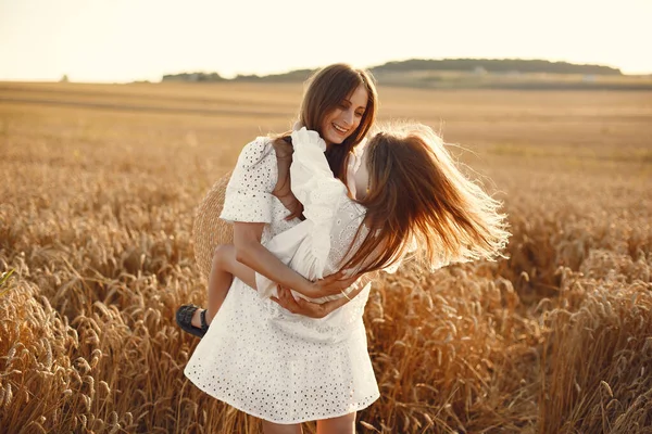 Mor med dotter på ett vetefält — Stockfoto
