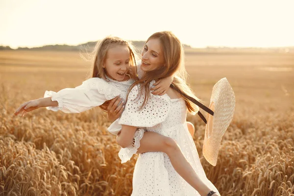 Moeder met dochter in een tarweveld — Stockfoto