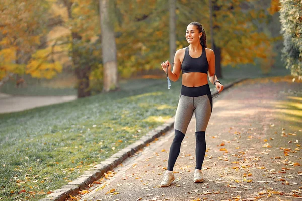 Ragazza sportiva in un top training nero in un parco autunnale — Foto Stock