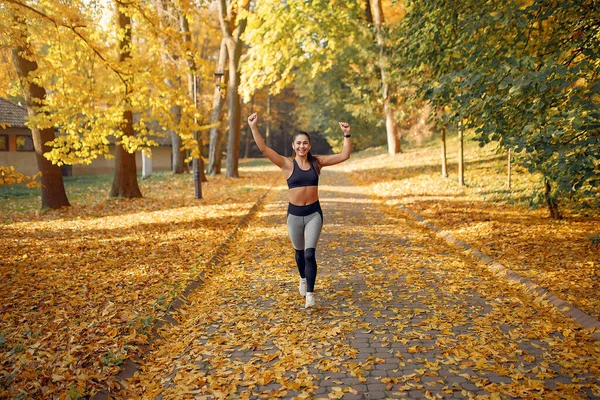 Jaki sport lubisz najbardziej? girl in a black top training in a autumn park — Zdjęcie stockowe