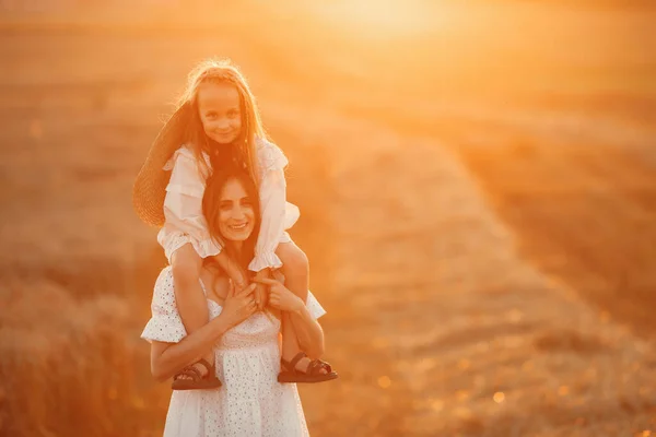 Moeder met dochter in een tarweveld — Stockfoto