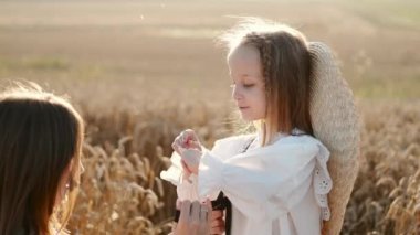 Anne ve kızı buğday tarlasında sarılıp eğleniyorlar.