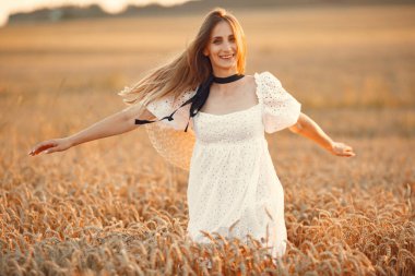 Sonbahar buğday tarlasında zarif bir kız.