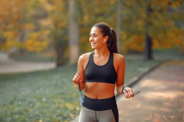 Sonbahar parkında siyah üst düzey bir eğitimde spor kızı.