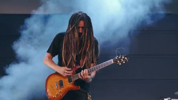 Guitarist performs on stage with electro guitar in smoke — Stock Video