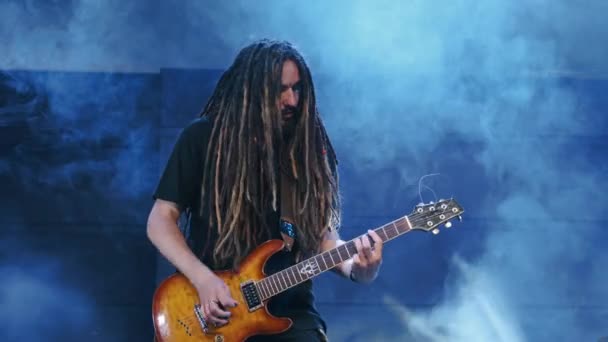 Kytarista vystupuje na jevišti s elektro kytarou v kouři — Stock video