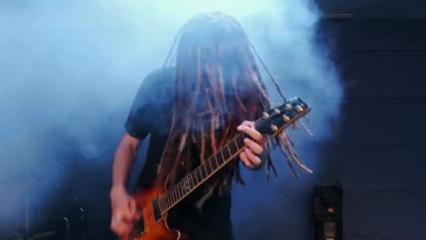 Kytarista vystupuje na jevišti s elektro kytarou v kouři — Stock video