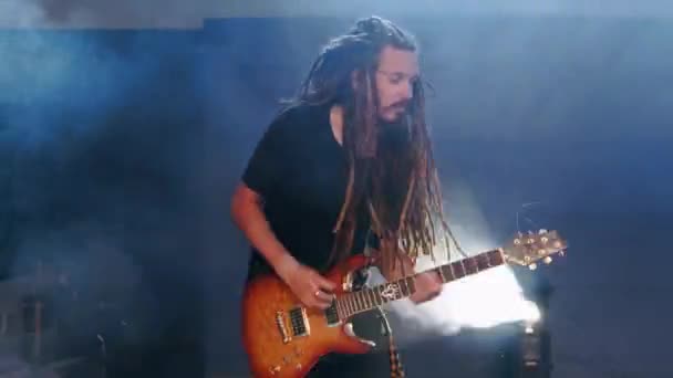 Гітарист виступає на сцені з електрогітарою в диму — стокове відео