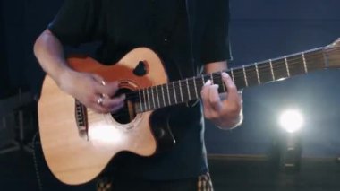 Şarkıcı bir konserde akustik gitar çalar.