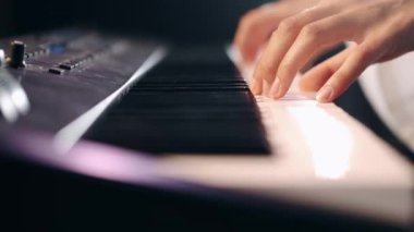 Sahnede eletric piyano çalan kadın eller