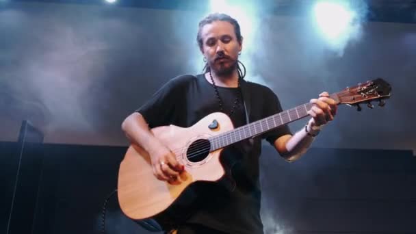 De zanger speelt een akoestische gitaar tijdens een concert — Stockvideo