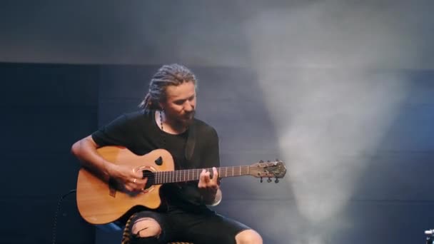 Ο τραγουδιστής παίζει ακουστική κιθάρα σε μια συναυλία. — Αρχείο Βίντεο