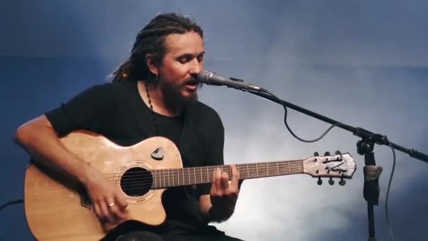 De zanger speelt een akoestische gitaar en zingt op een concert — Stockvideo