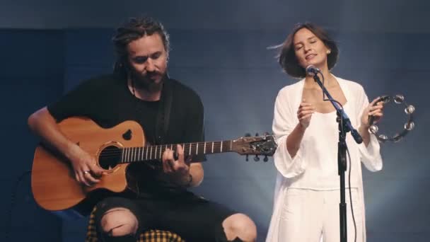 Cantante femenina con pandereta y músico tocando la guitarra en el escenario — Vídeo de stock