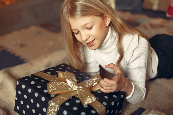 Kislány egy fehér pulóverben közel karácsonyfa ajándékkal — Stock Fotó