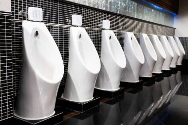 white urinal in men public toilet with black wall tile clipart