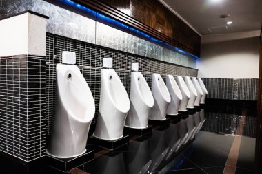 Beyaz pisuar olarak erkekler umumi tuvalet ile siyah duvar karosu