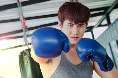 Boks kum torbasına spor kulübünde üzerinde pratik genç yakışıklı bir Asya adam portresi