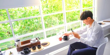 Genç erkek kahve yemek ve cam şişede güzel balık bir fotoğraf çekmek.