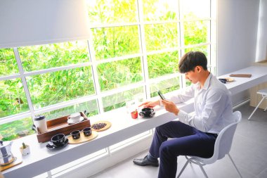 Genç erkek kahve yemek ve cam şişede güzel balık bir fotoğraf çekmek.