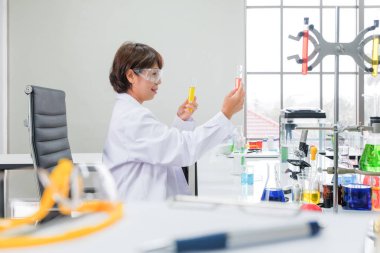 Bilim adamları laboratuarda çalışıyoruz. Genç kadın araştırmacı ve onu test tüpleri ile araştırmalar yapıyoruz.