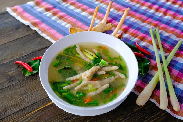 Spicy chicken legs Soup in white cup on wooden table