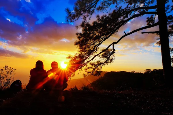 Silhouette of happy young couple in love looking view sunset on the mountain. Romantic couple in love