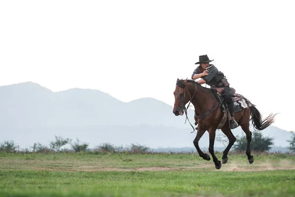 Egy cowboy ruhás férfi a lovával. — Stock Fotó