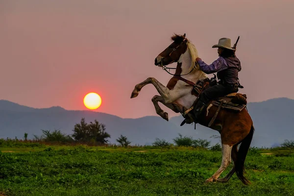 Egy cowboy ruhás férfi a lovával. — Stock Fotó