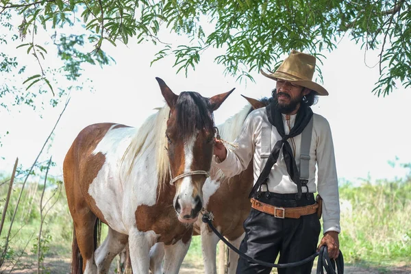 カウボーイの服を着た男が馬と一緒に — ストック写真