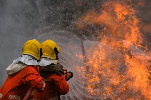 Hasič používá vodu v boji proti požárním operacím — Stock fotografie