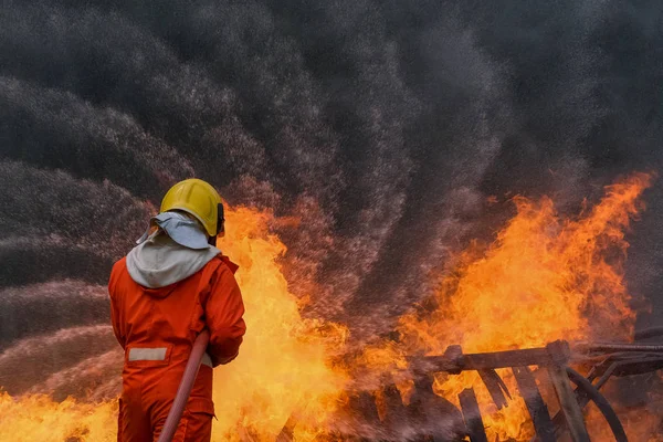 Firefighter are using water in fire fighting operation — Stock Photo, Image