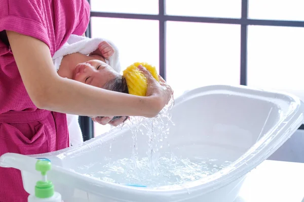 The mother cleaned the baby 2 months old, lying on the white clo — Stock Photo, Image